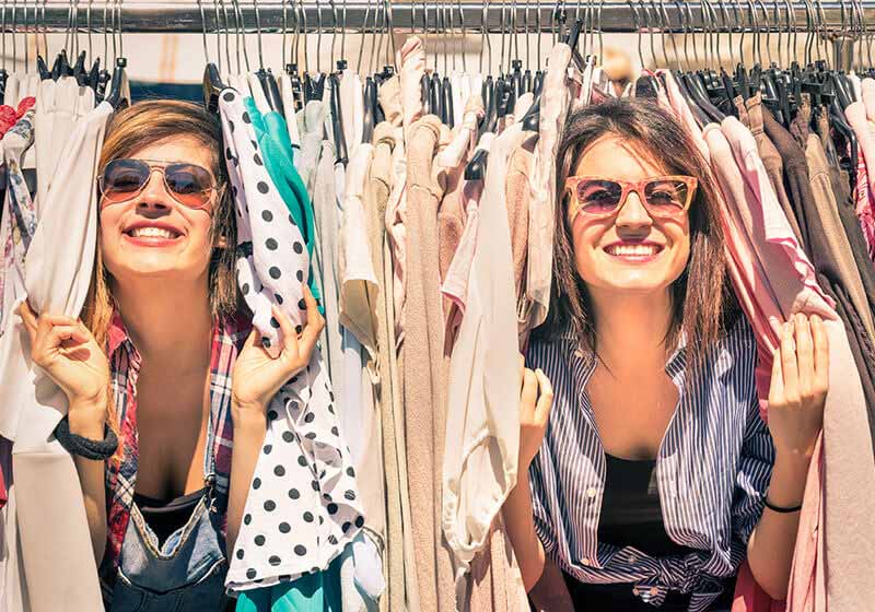 Ladies peeking though clothing rack