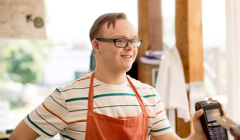 happy disabled man working at café smiling