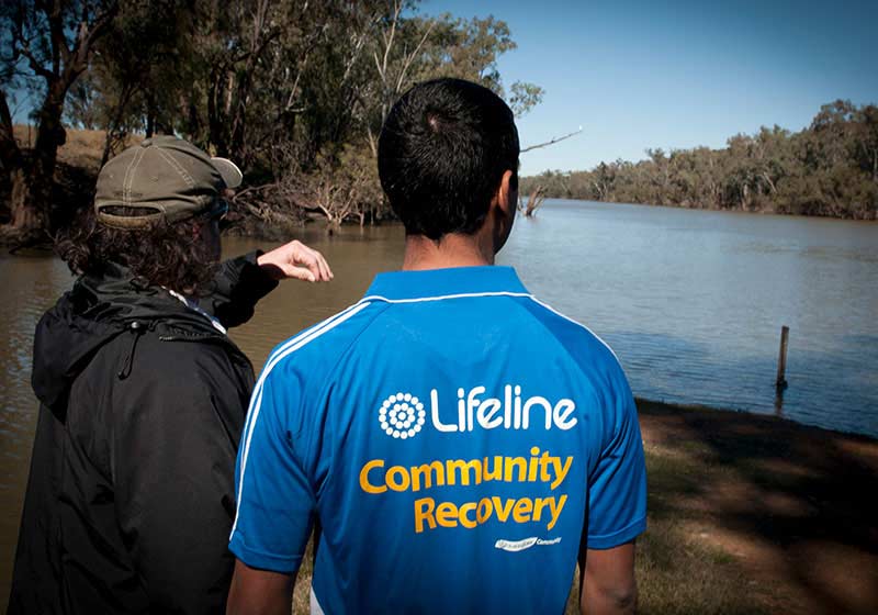 lifeline worker surveying flooded land