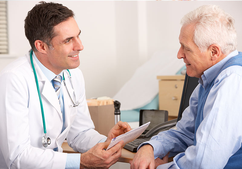 male doctor mid conversation with elderly male patient