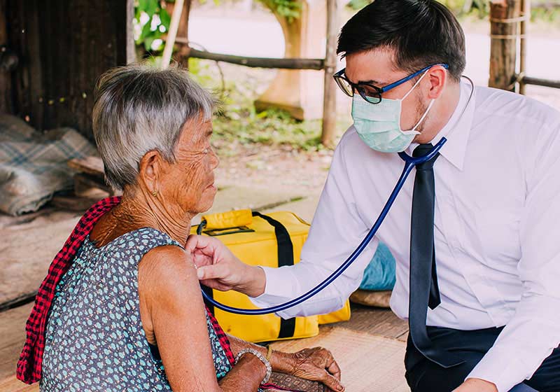 male doctor treating elderly rural patient