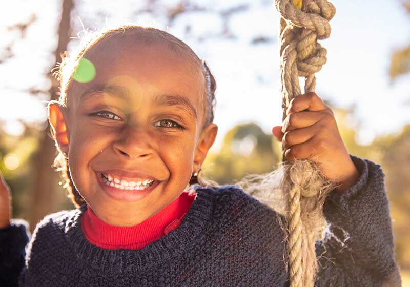 Young smiling girl on swing