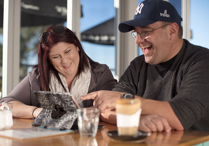 Man and woman at cafe reviewing documents on an iPad