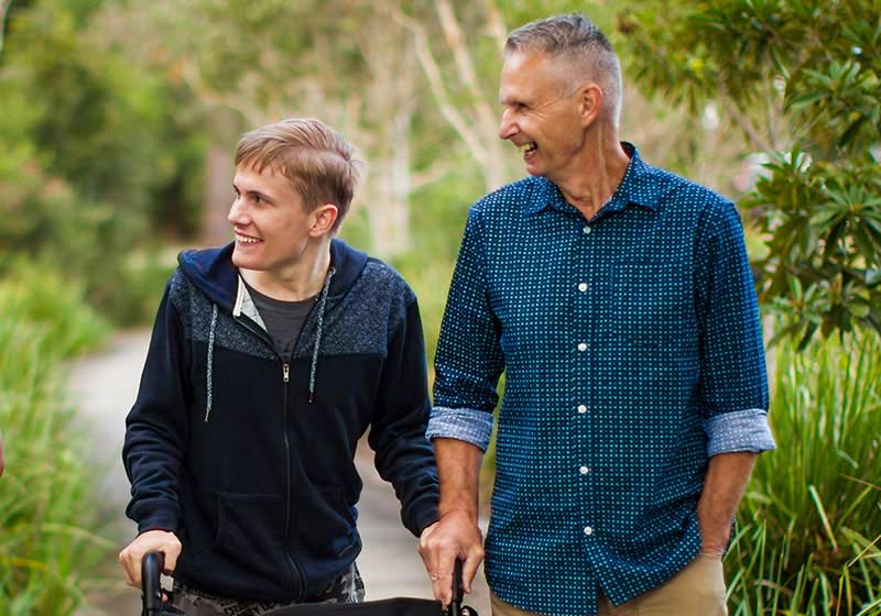 father with a disabled son walking in the nature