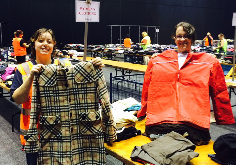 two people holding clothes at warehouse sale