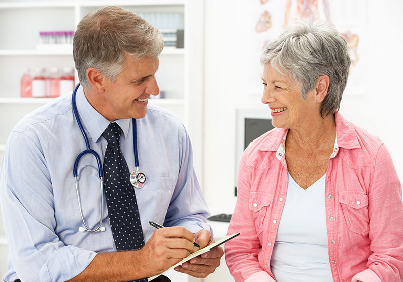 grey haired doctor consulting elderly woman patient