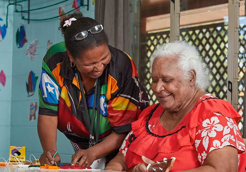 Two Aboriginal women talking at a table
