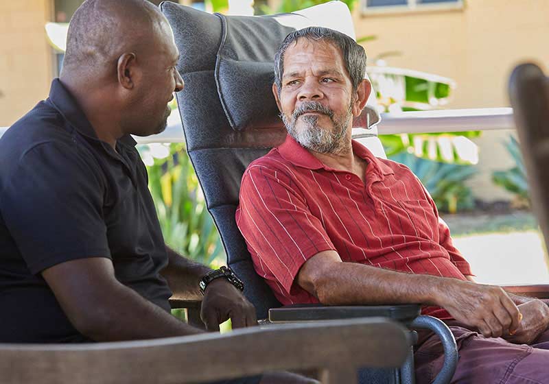 two men sitting down talking