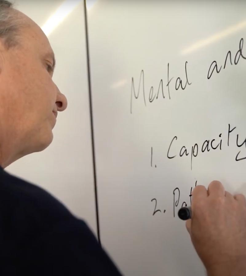 A man writing information on a whiteboard