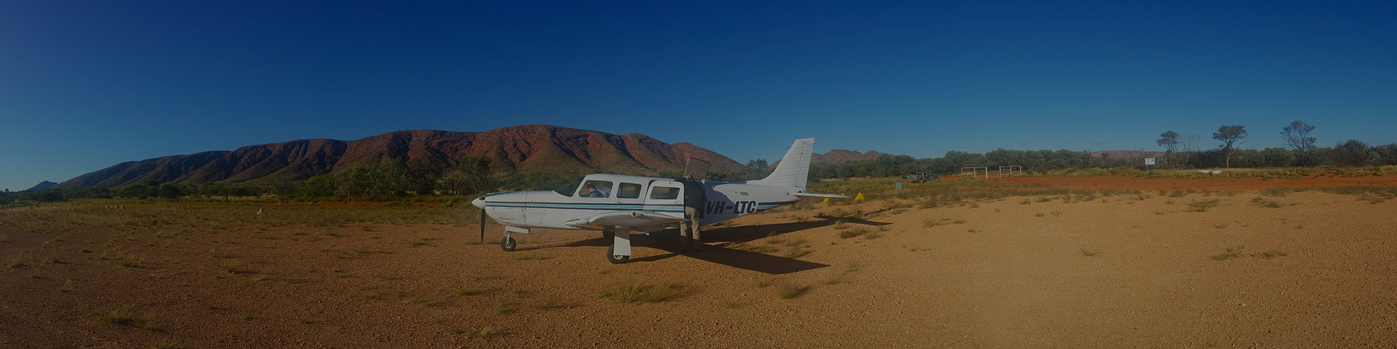 small plane grounded in a rural desert landscape