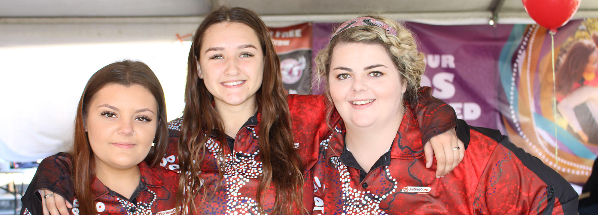 Three girls smiling at camera at NAIDOC event