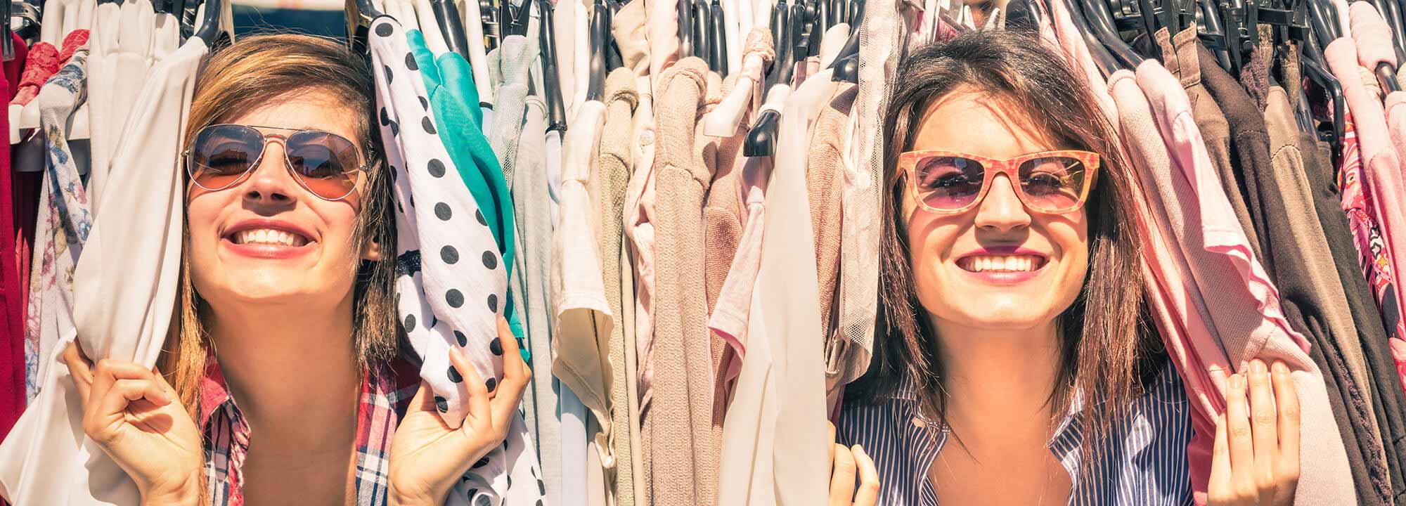 Ladies peeking though clothing rack