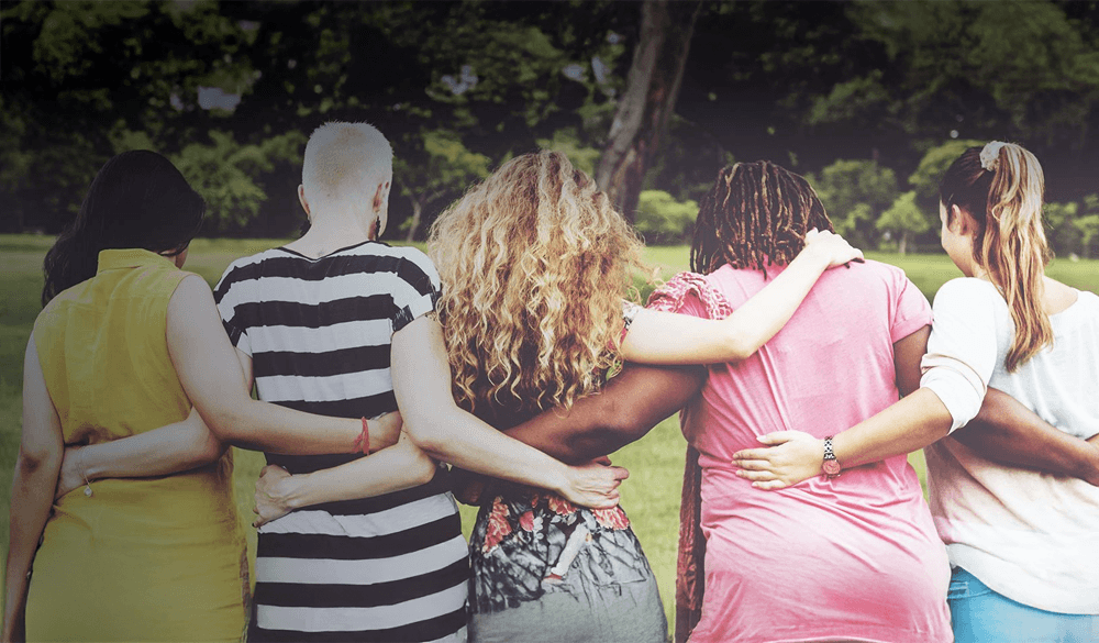 A group of people in a line facing away and embracing each other