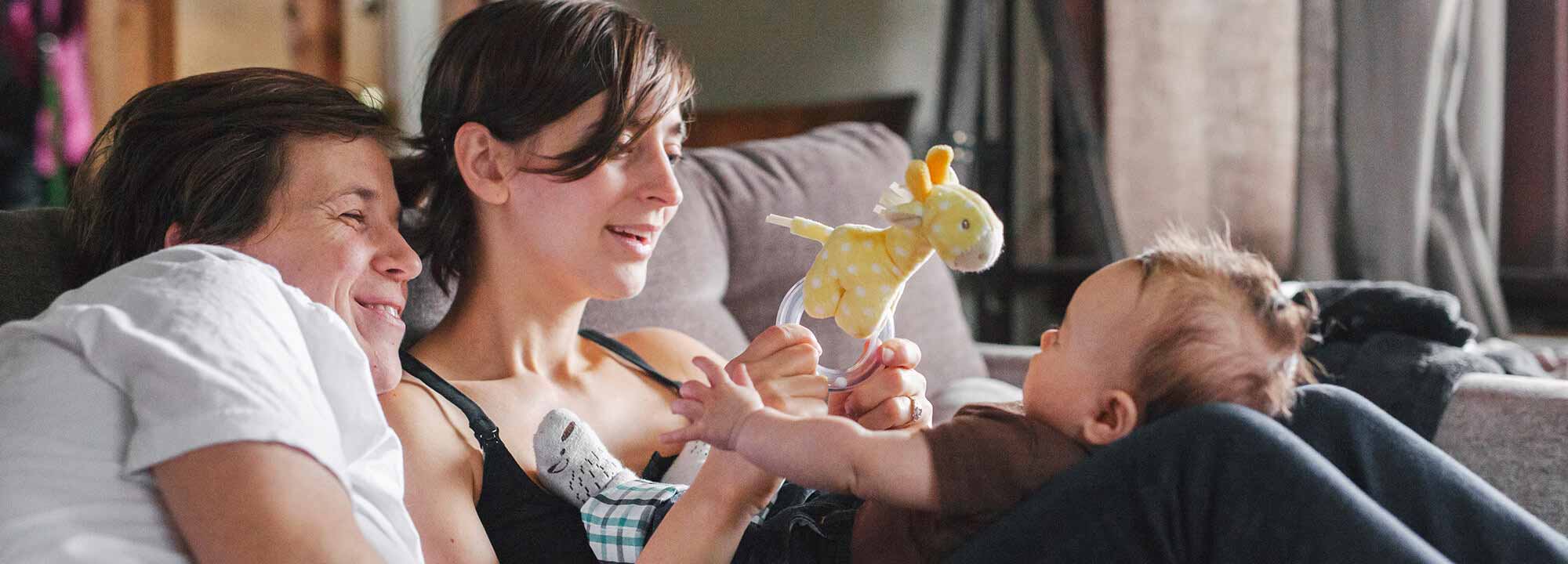 Parents with child playing on couch