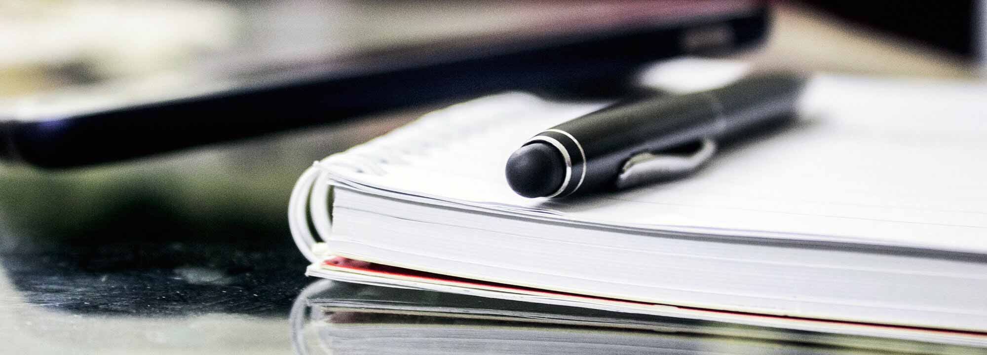 Close up of pen and book on table