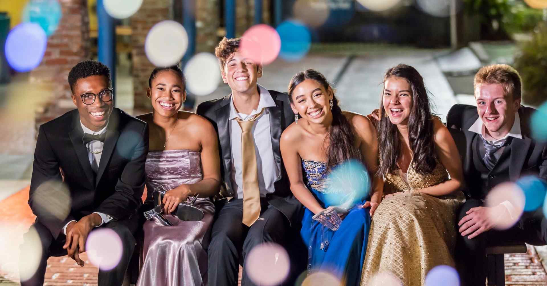 A group of students in formal wear smiling together