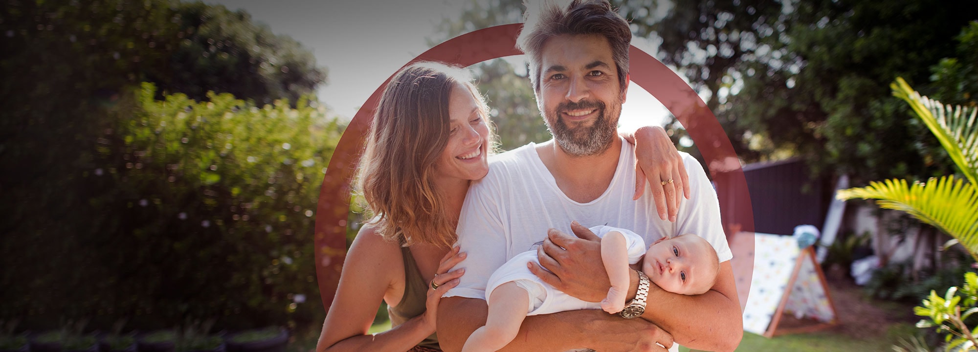 man and women embracing with an infant child laying in the man's arms