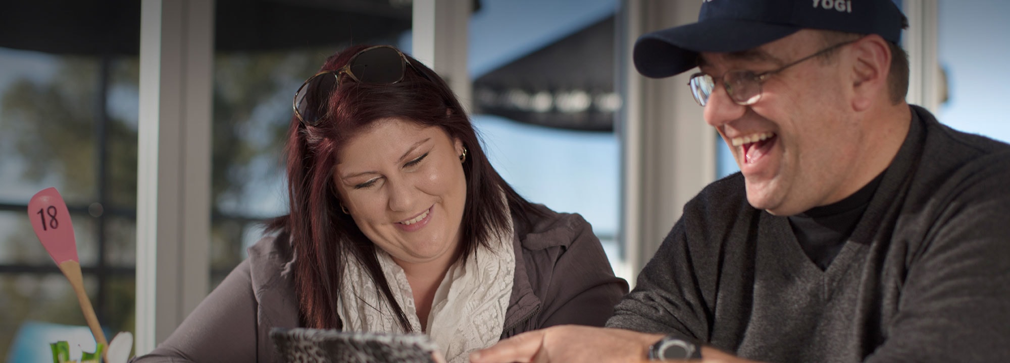 man with glasses laughing with a smiling woman
