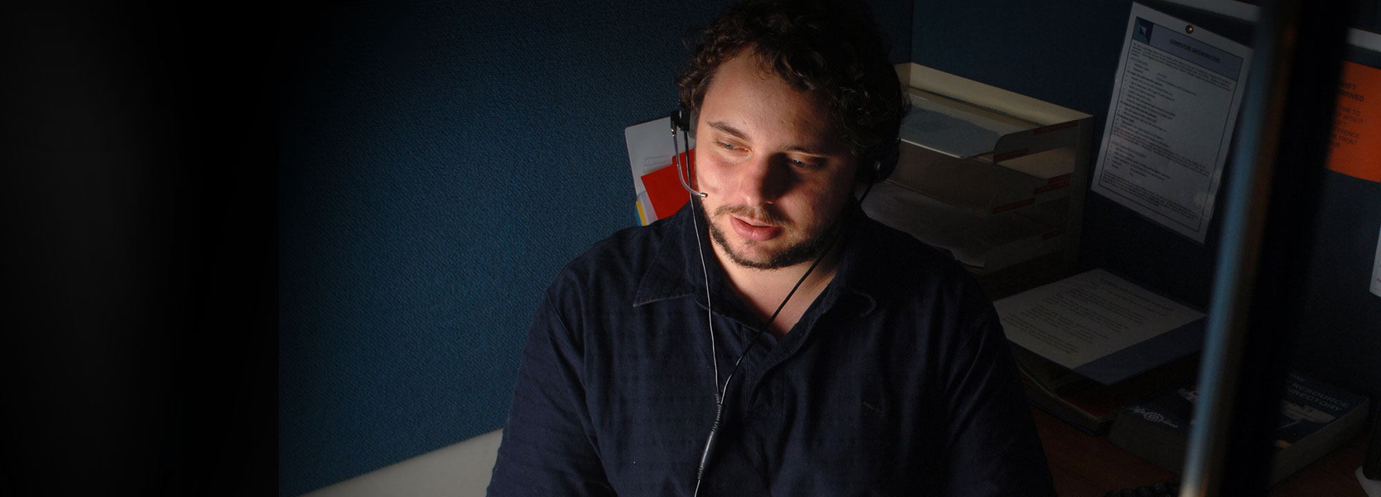 male staff member wearing a headset on a telephone conversation