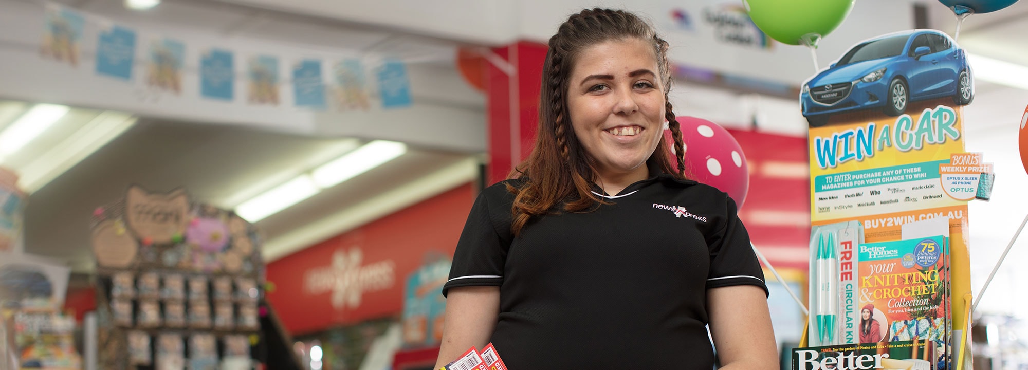 a young girl with brown braided hair standing inside a store