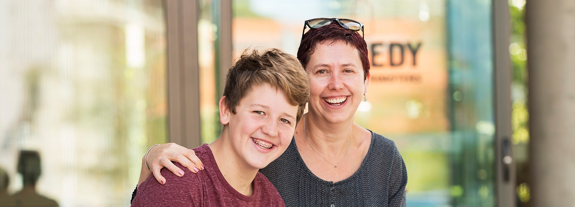 mother sitting with her teenage son outdoors smiling