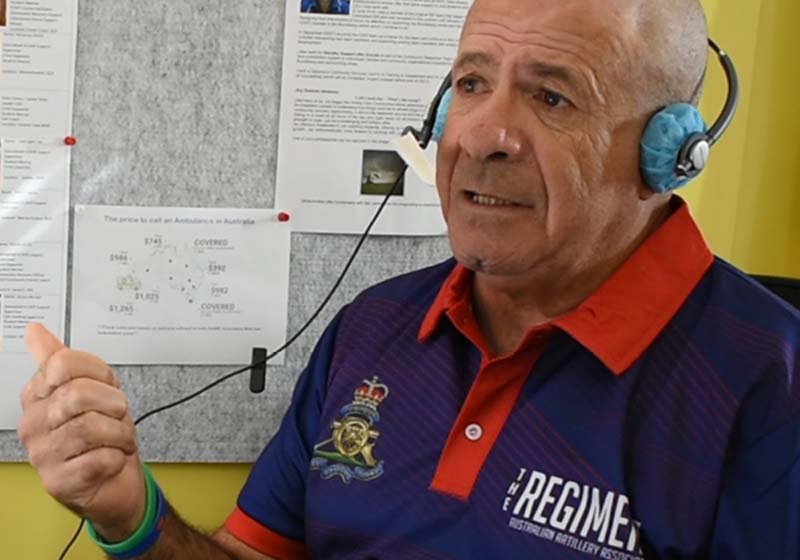 An Indigenous man with a headset answering calls