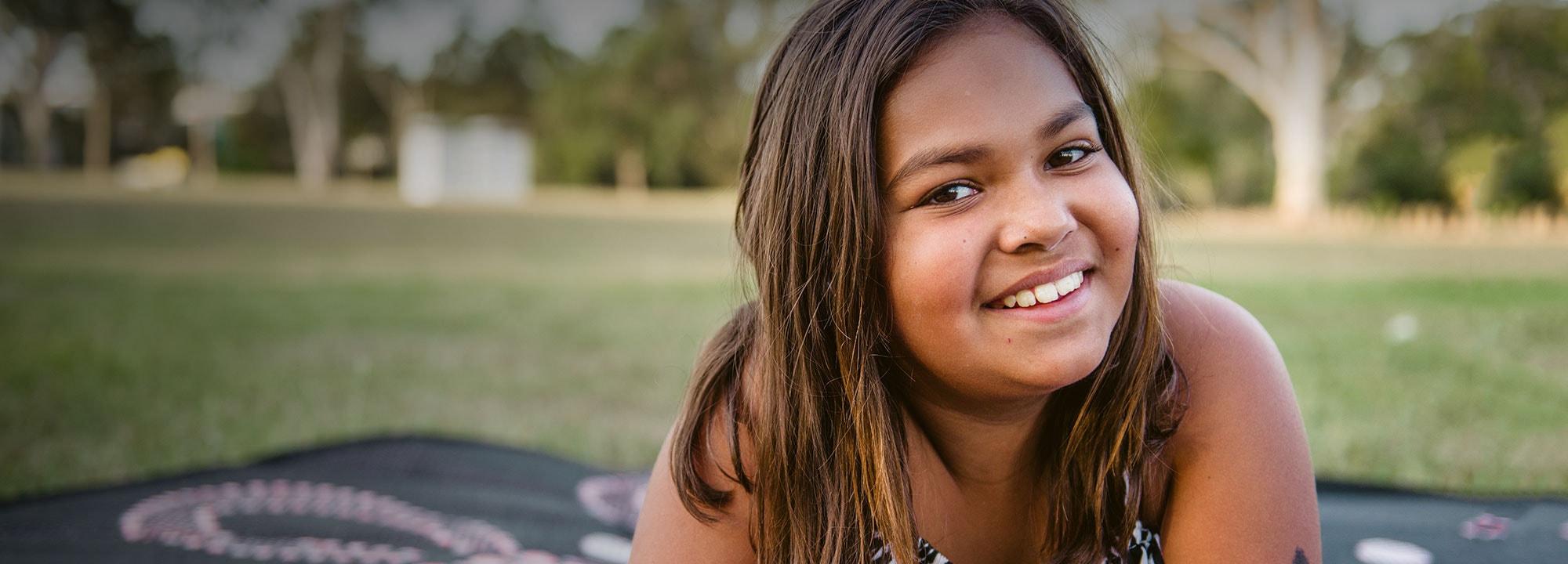 young indigenous girl laying outdoors