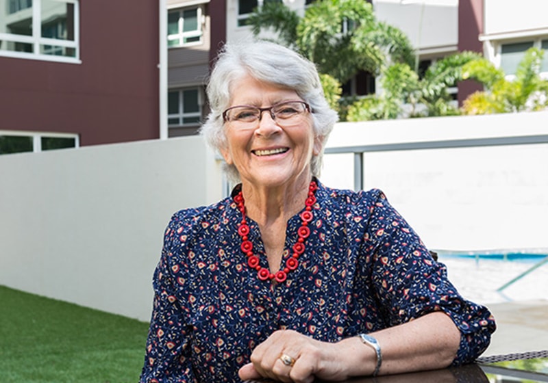 elderly lady sitting outside smiling