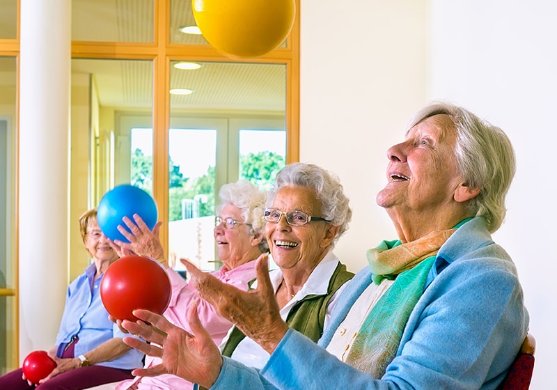 elderly women having fun with balloons