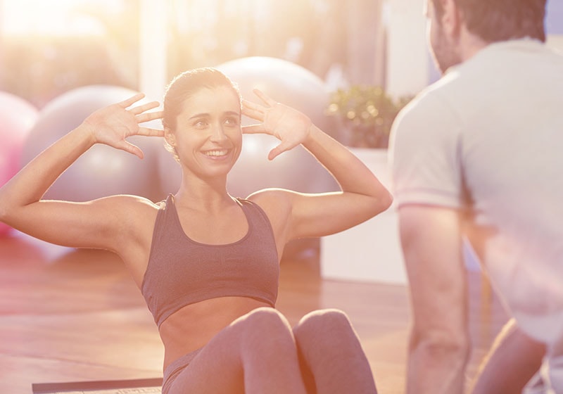 happy fir girl working out with personal trainer