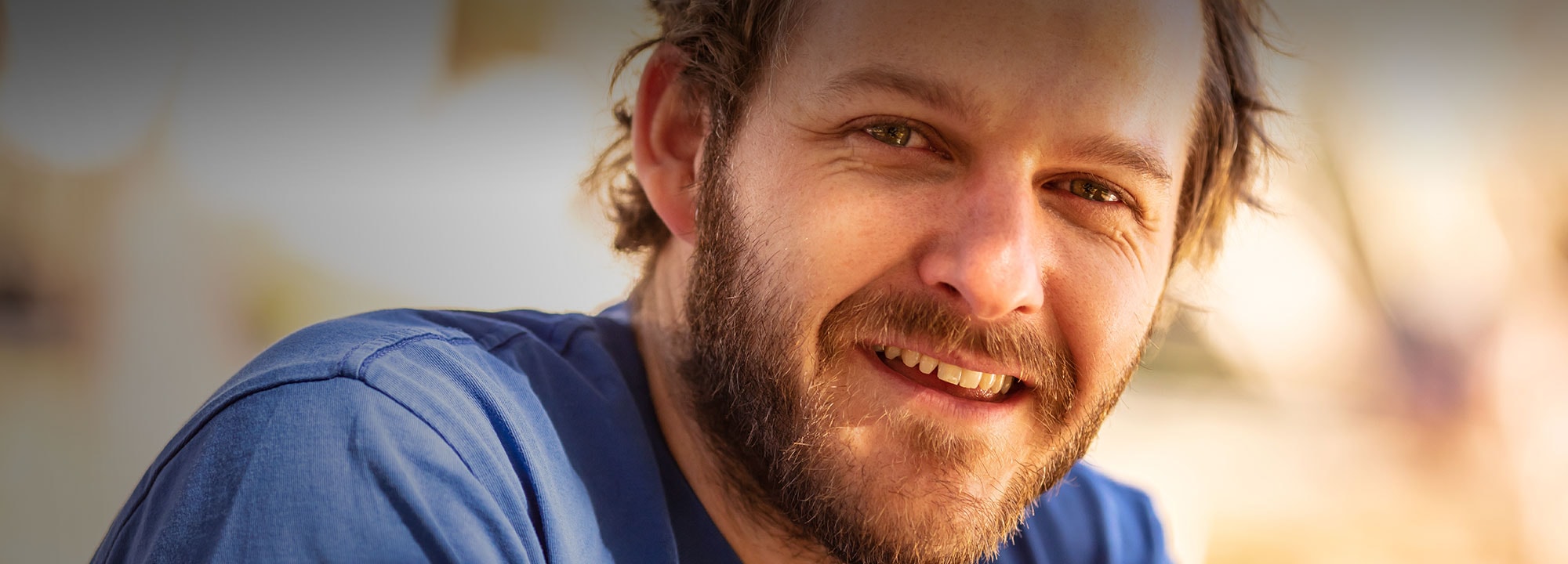 young man wearing a blue shirt smiling