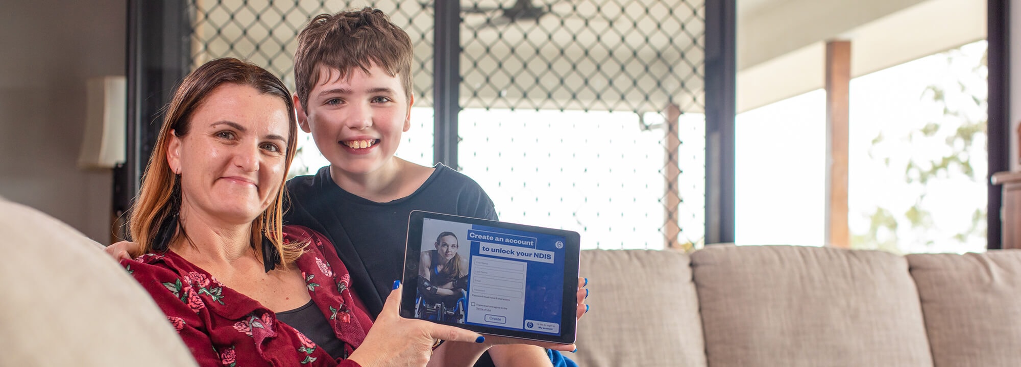 Mother and son holding tablet with NDIS planning App