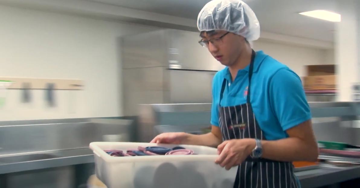 man washing dishes in a commercial kitchen