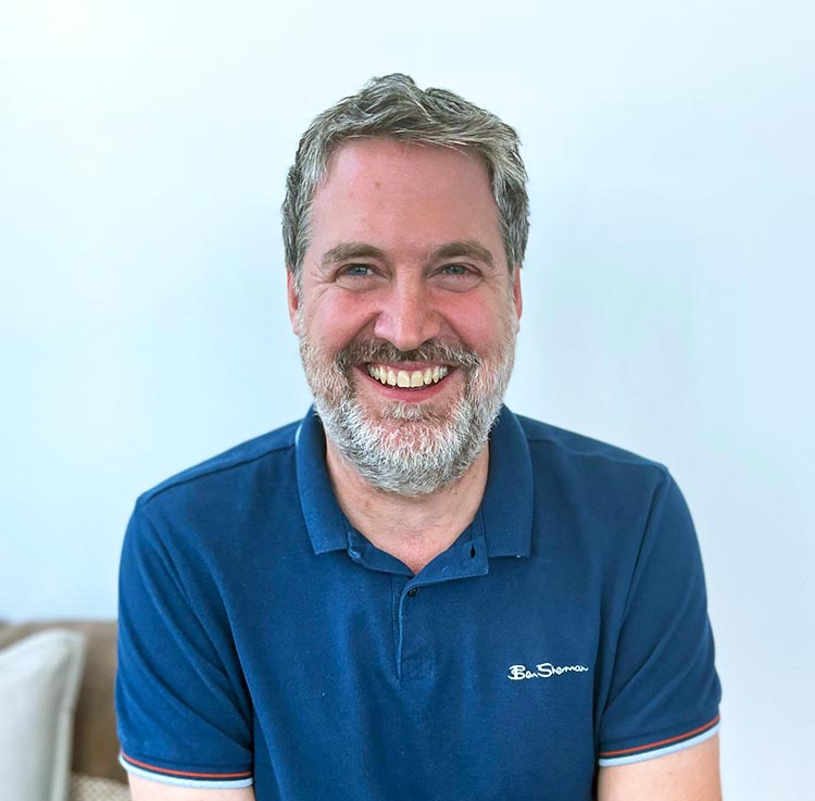 Close-up picture of a man smiling at the camera